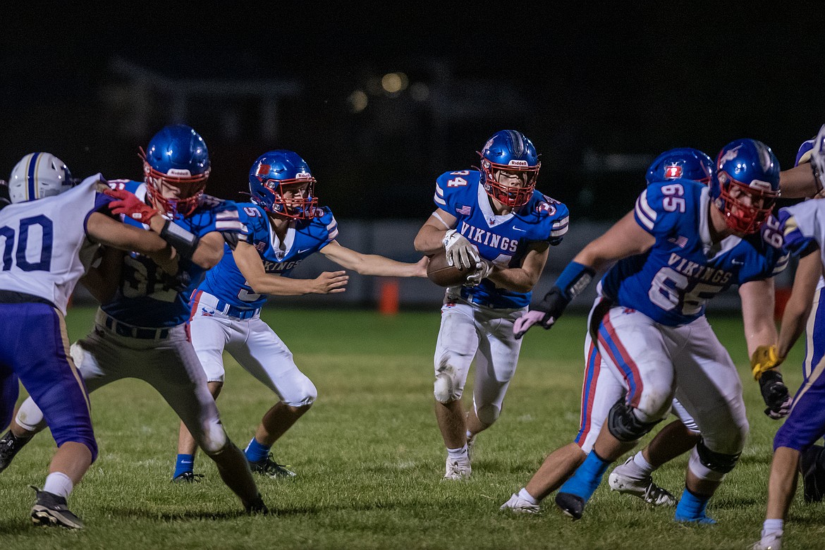 Quarterback Alex Ochs hands off to running back Dane Carlsen playing Polson Friday, Aug. 30. (Avery Howe/Bigfork Eagle)