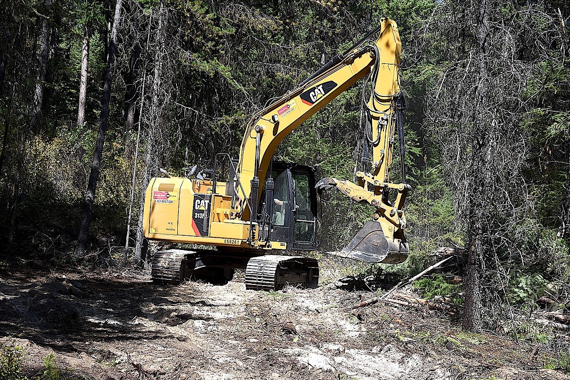 The operator of an excavator clears a Kelly-humped road Wednesday, Sept. 4, 2024, on Cougar Ridge in the Kootenai National Forest. The road was cleared so fire crews and a water tender could travel up the road to battle a small wild fire. (Scott Shindledecker/The Western News)