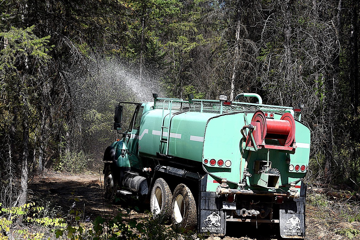 A.J. Faur, the operator of a U.S. Forest Service water tender, sprays water on a Kelly-humped road to stabilize it Wednesday, Sept. 4, 2024, on Cougar Ridge in the Kootenai National Forest. The road was cleared so fire crews and a water tender could travel up the road to battle a small wild fire. (Scott Shindledecker/The Western News)