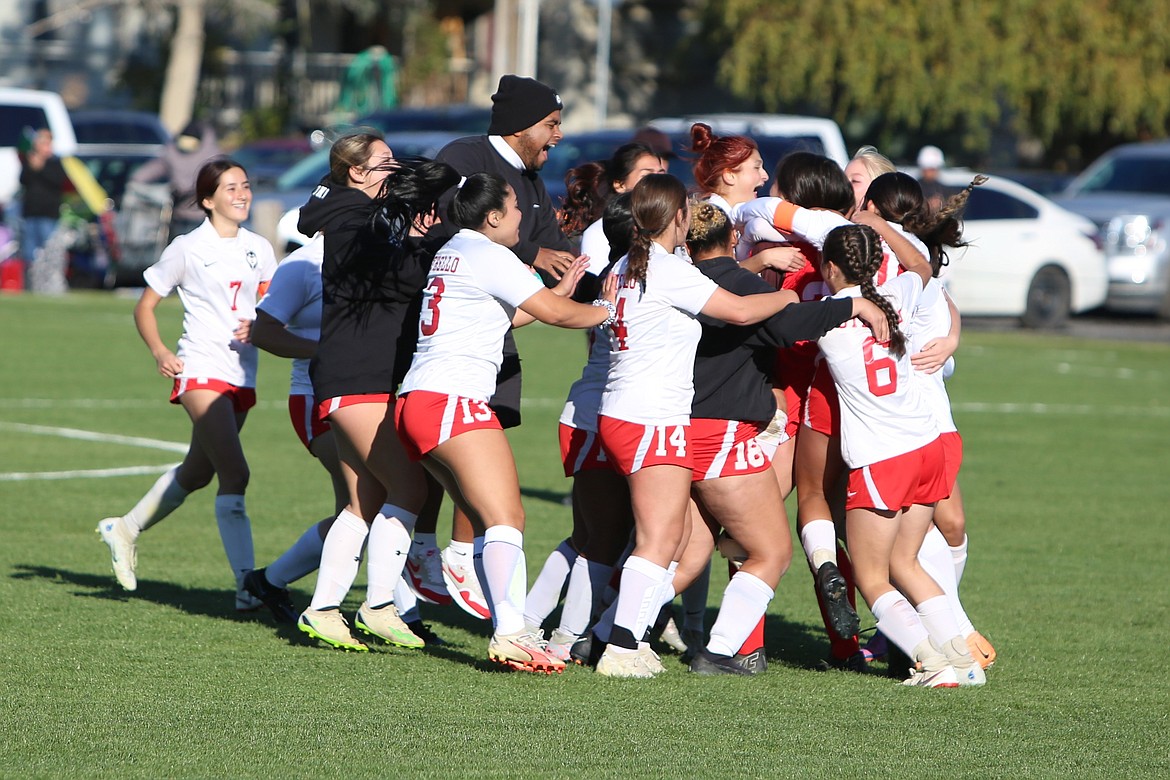 Othello girls soccer players and coaches celebrate after defeating Ephrata in the Central Washington Athletic Conference district tournament last season.