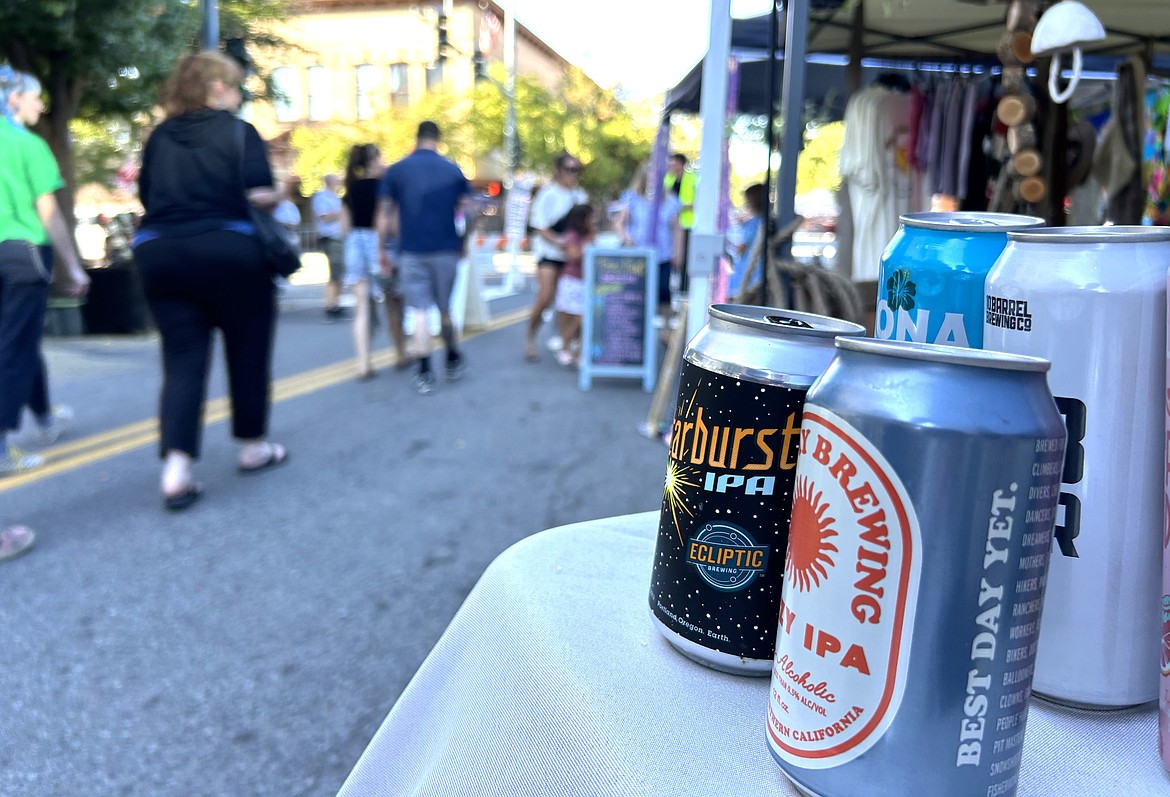 Visitors pass by the booth offering beer and wine at the 5th Street Farmers Market on Wednesday.