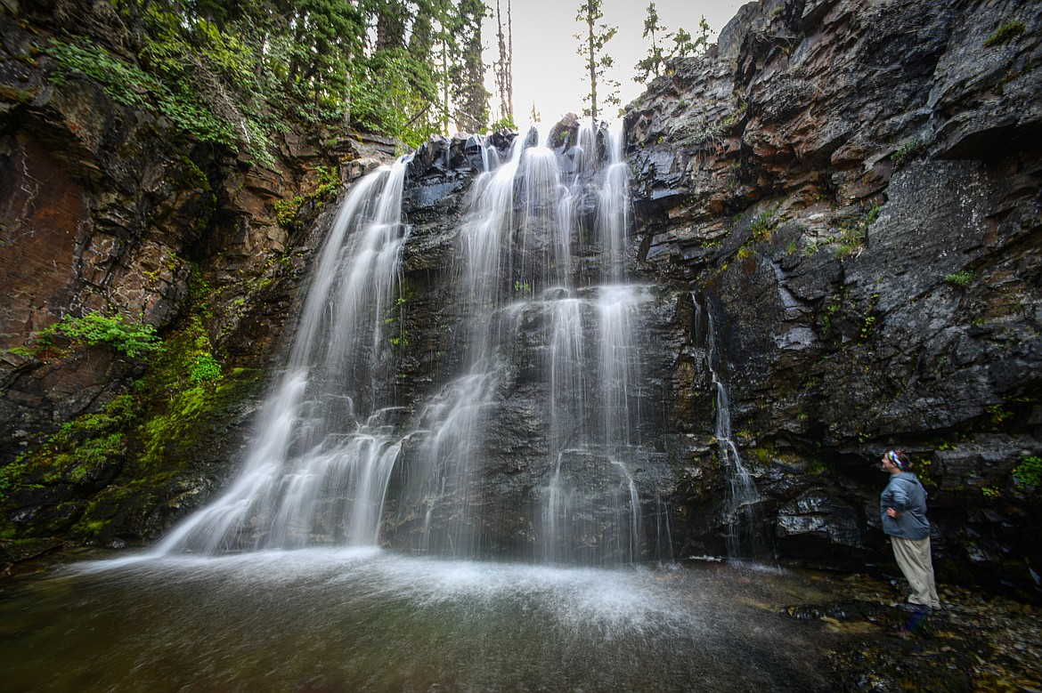 Cooling off under the lower section of Rockwell Falls along the Two Medicine Pass Trail in Glacier National Park on Sunday, Aug. 11. (Casey Kreider/Daily Inter Lake)