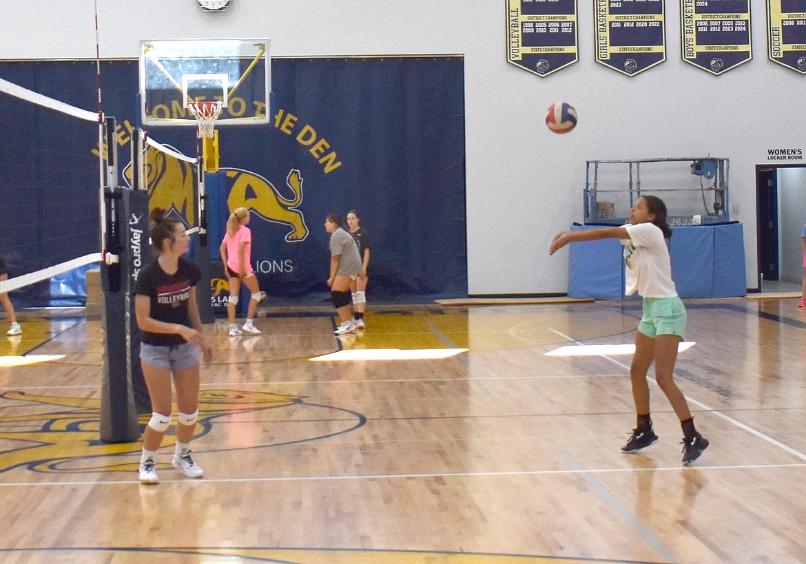 Brooklyn Dorsing, left, keeps her eye on the ball as SanTahna Ferguson bumps it into the air at Moses Lake Christian Academy/Covenant Christian School volleyball practice Aug. 30.