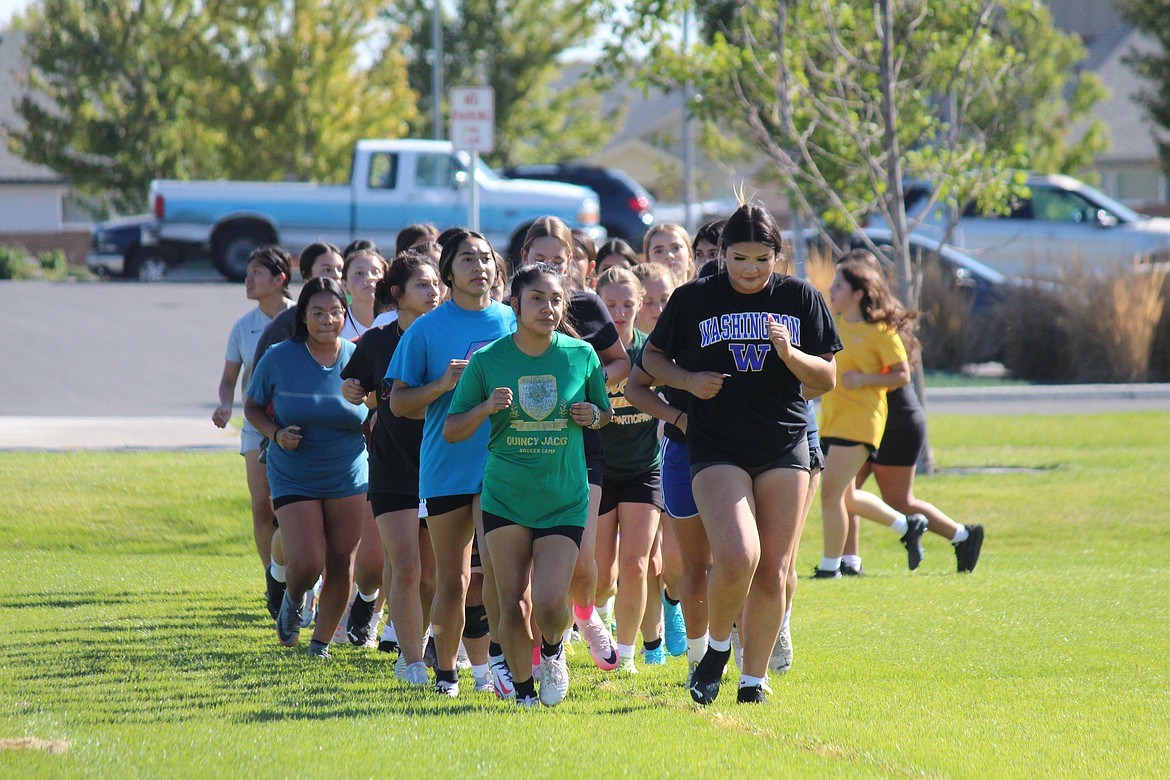 The girls soccer team takes a lap around the Quincy High School practice field.