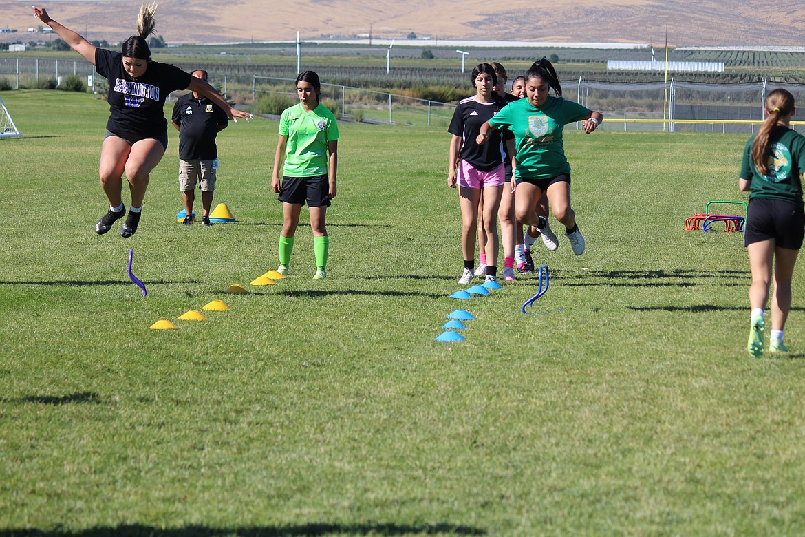 Quincy girls soccer players warm up in early-practice drills.