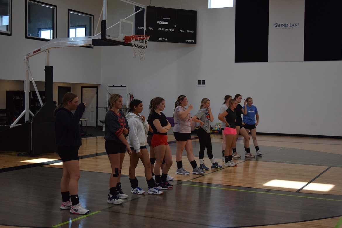 The Wilson Creek volleyball squad listens to instructions from Coach Christa Christopherson prior to practicing drills Tuesday.