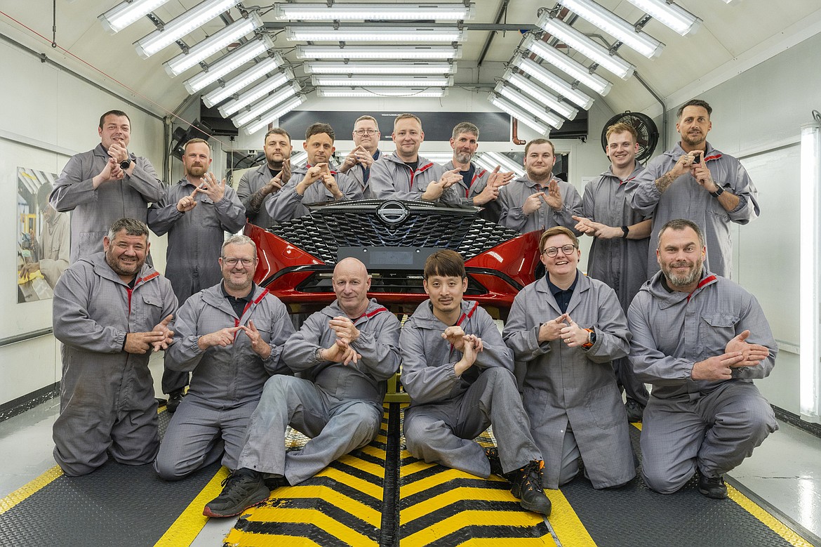 In this photo provided by Nissan on Thursday, Sept. 5, 2024, workers of Nissan's plant’s Paint Shop including John Johnson, foreground right and Michael Connolly, foreground, second left, pose for a photo at the plant, in Sunderland, England. (Matt Walker/Nissan via AP)