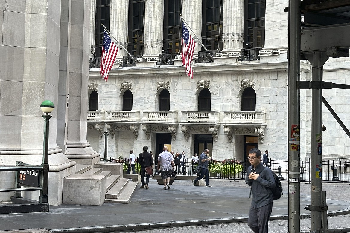 FILE - People pass the New York Stock Exchange, at rear, on Aug. 27, 2024, in New York. (AP Photo/Peter Morgan, File)