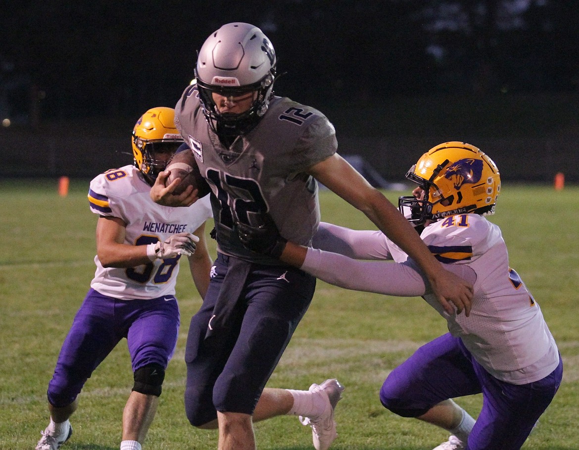 JASON ELLIOTT/Press
Lake City senior quarterback Avrey Cherry fights out of the grasp of Wenatchee linebacker Ezekiel Tapia during the second quarter of Friday's game at Van Troxel Field.