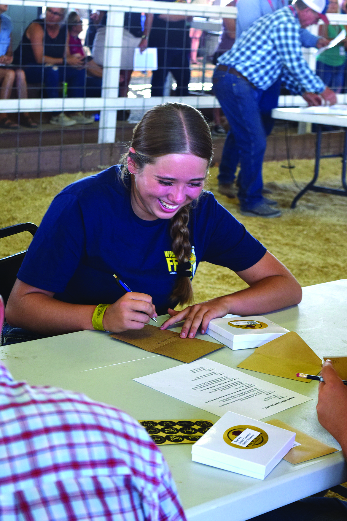 Award winners, after accepting their belt buckle, sat down at tables to write thank you cards.