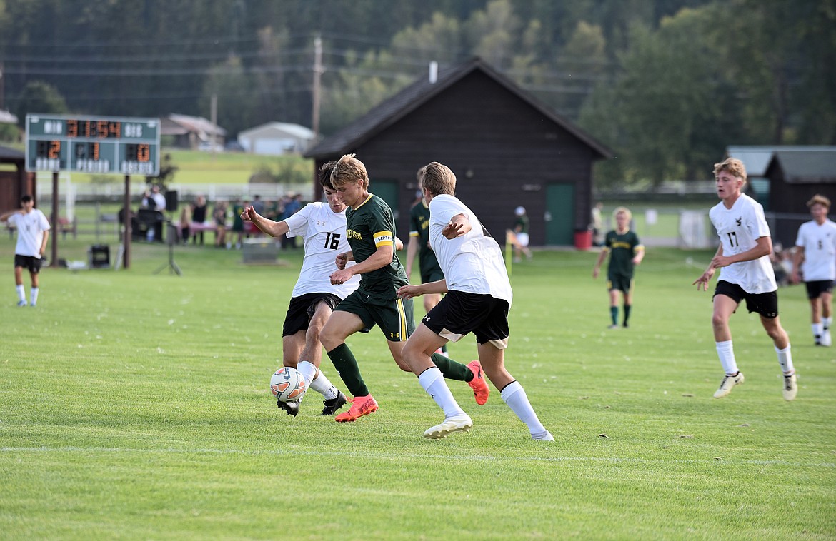 Bulldog captain, Preston McPherson, splits two defenders while heading up field Whitefish's first home game last week. (Julie Engler/Whitefish Pilot)