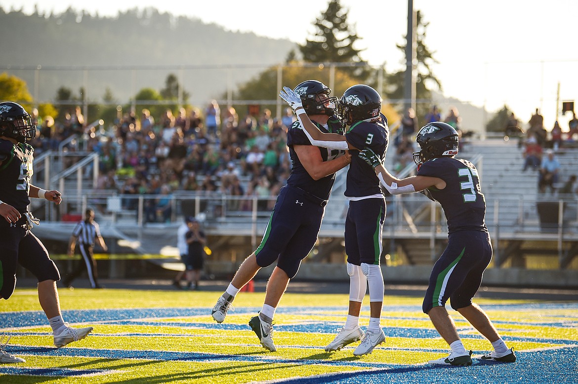 Glacier's William Astle (56), Micah Klippenstein (3) and Ethan Anderson (37) celebrate after Klippenstein's touchdown catch in the first quarter against Billings Senior at Legends Stadium on Friday, Sept. 6. (Casey Kreider/Daily Inter Lake)