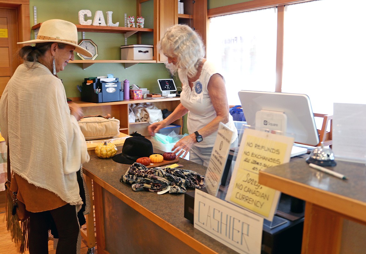 Marcia Hutson gets check out by CAL member Ann Nichols as the longtime community group celebrated the grand opening of Bizarre Bazaar on Saturday.