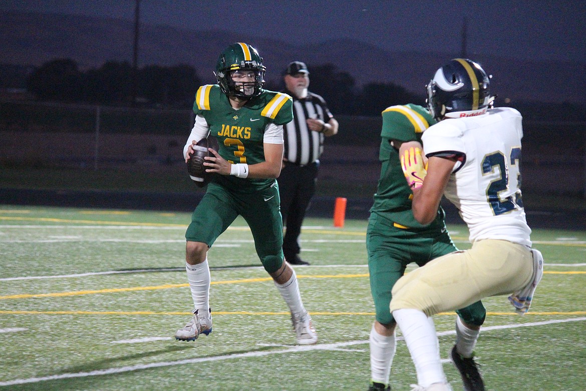 Quincy quarterback Pierce Bierlink (3) rolls out to pass In Quincy’s season opener Friday.