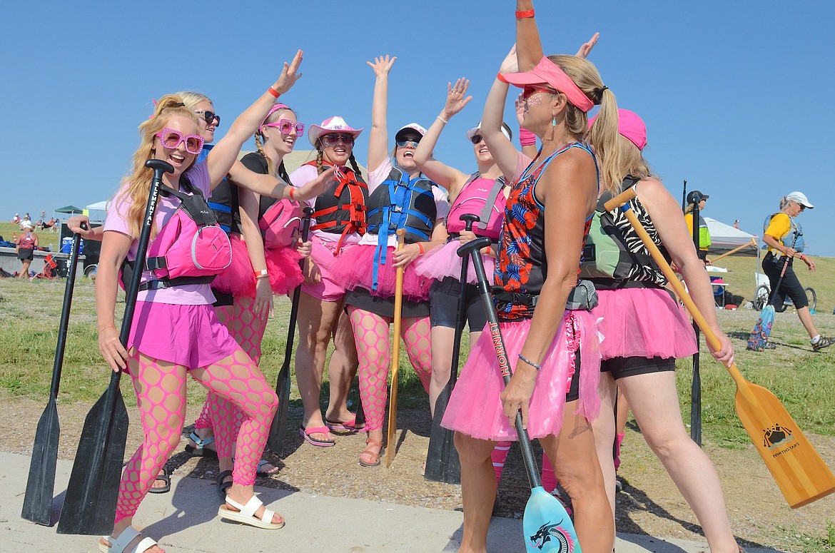 Women in pink give a fervent high five before boarding their dragon boat during Saturday's races on the Flathead River. The festival attracted eight teams from across Montana and Canada. (Kristi Niemeyer/Leader)