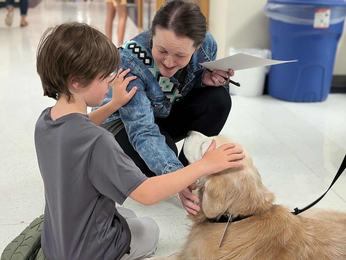 Kelly Breakie and son Odin Breakie pet Llamah Owen, Bryan Elementary comfort dog, Aug. 28 during the Bryan Elementary open house.