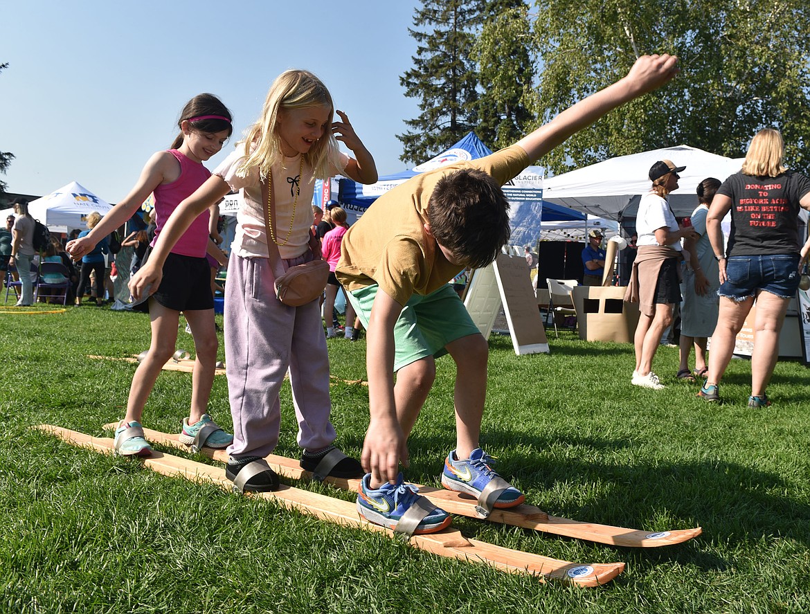 Jack, Jessa and Isabel say "left, right, left, right!" to move as trio on Glacier Nordic Ski Club's makeshift skis at the Great Fish Community Challenge Fun Run. (Kelsey Evans/Whitefish Pilot)