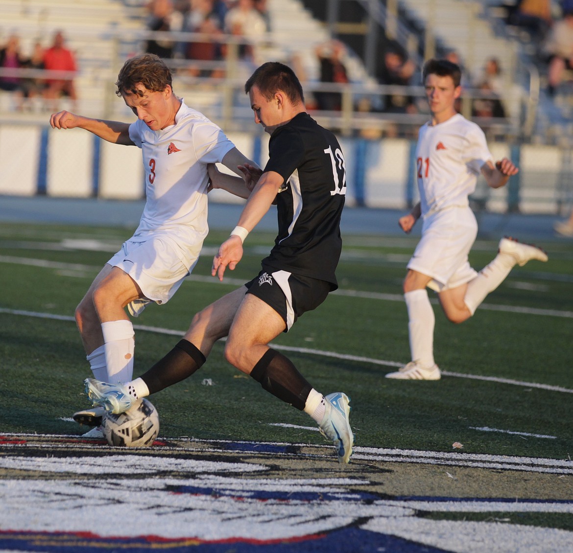 JASON ELLIOTT/Press
Coeur d'Alene senior midfielder Keaton Gust plays the ball off his foot as Post Falls senior fullback Jacob Smith defends during the first half of Tuesday's Inland Empire League match at Viking Field.