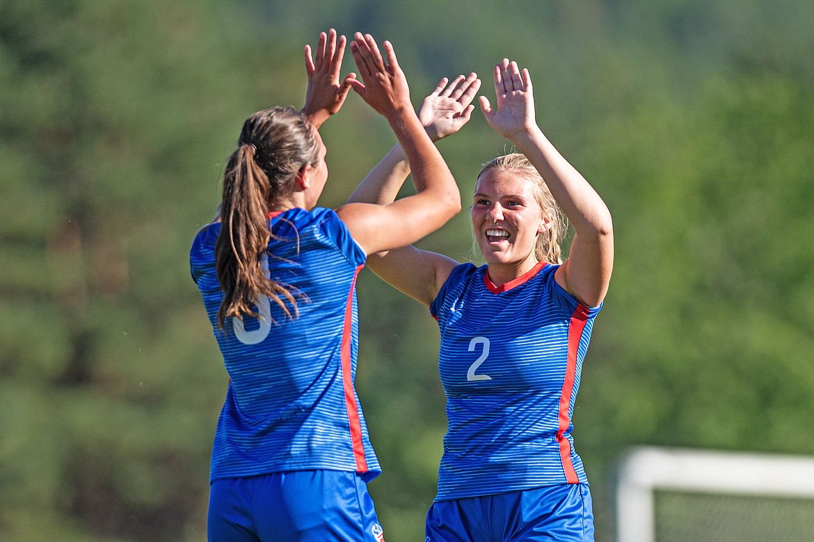 Paeten Gunlock and Gracie Johnson celebrate a Bigfork point on Thursday. (Avery Howe/Bigfork Eagle)