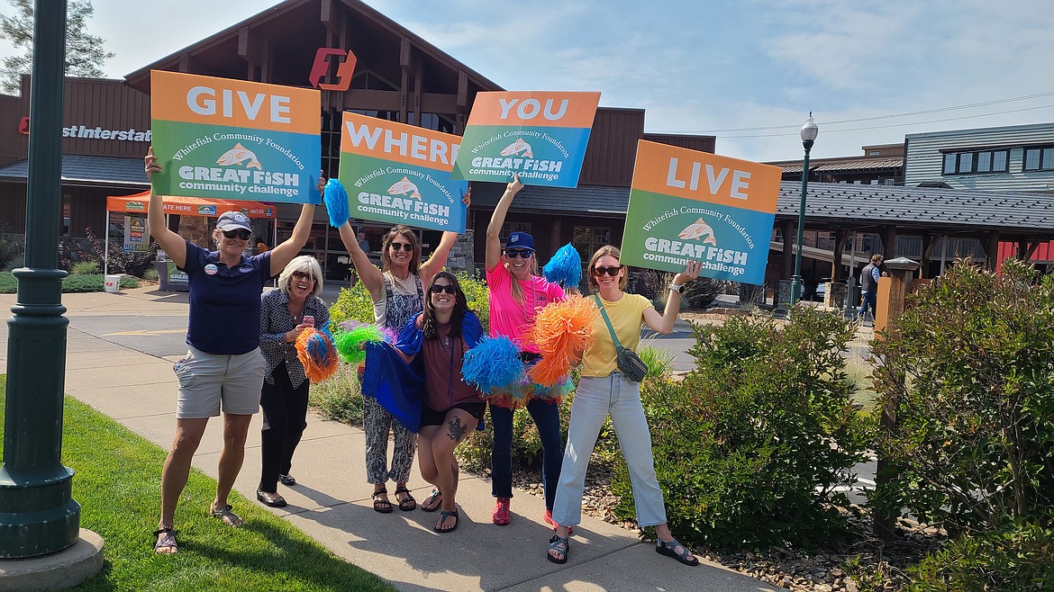 Representatives from nonprofits participating in the 2024 Great Fish Community Challenge wave signs at a pop-up donation station in Whitefish on Sept. 10. (Courtesy photo)