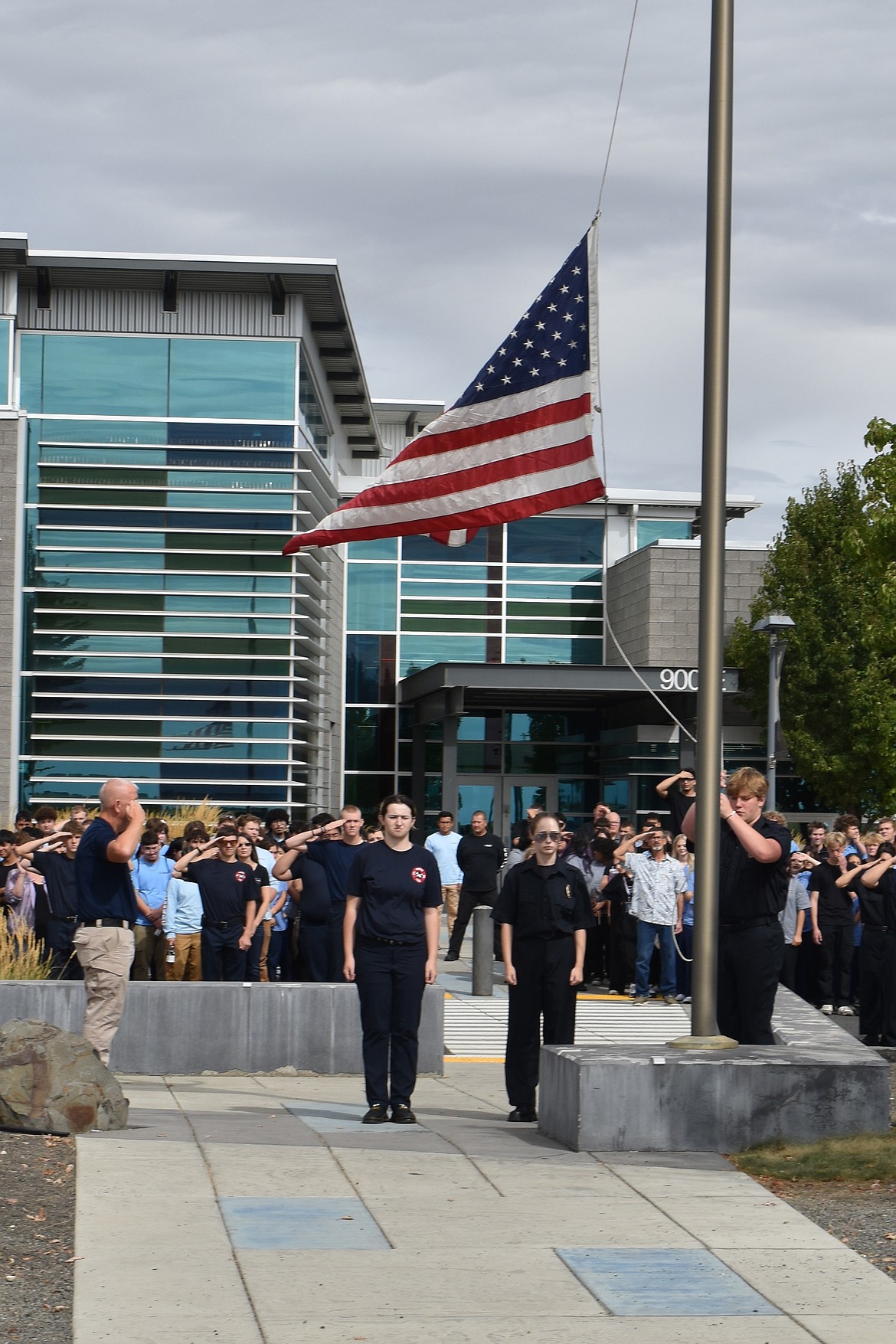 From left: Columbia Basin Technical Skills Students Sarah Crozier, Felix Nuetzhorn and Sean King raise a flag at the 9/11 memorial Wednesday morning.