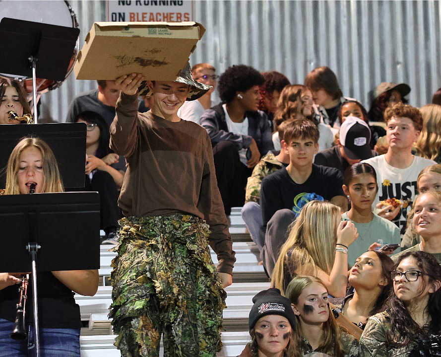 Ephrata High School senior Zander Leasher makes his way through the student section with a pizza during a Sept. 6 football game against Prosser. EHS students dressed in camouflage as part of First Responders Appreciation Night. The Tigers won the game 15-13.