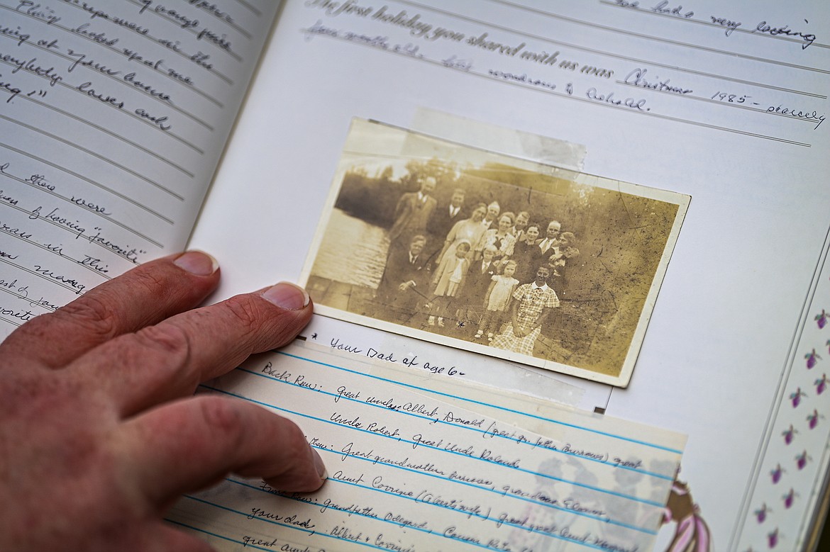 Ike Odegard points to an old photo of the Odegards in a family memory book on Thursday, Sept. 12. (Casey Kreider/Daily Inter Lake)