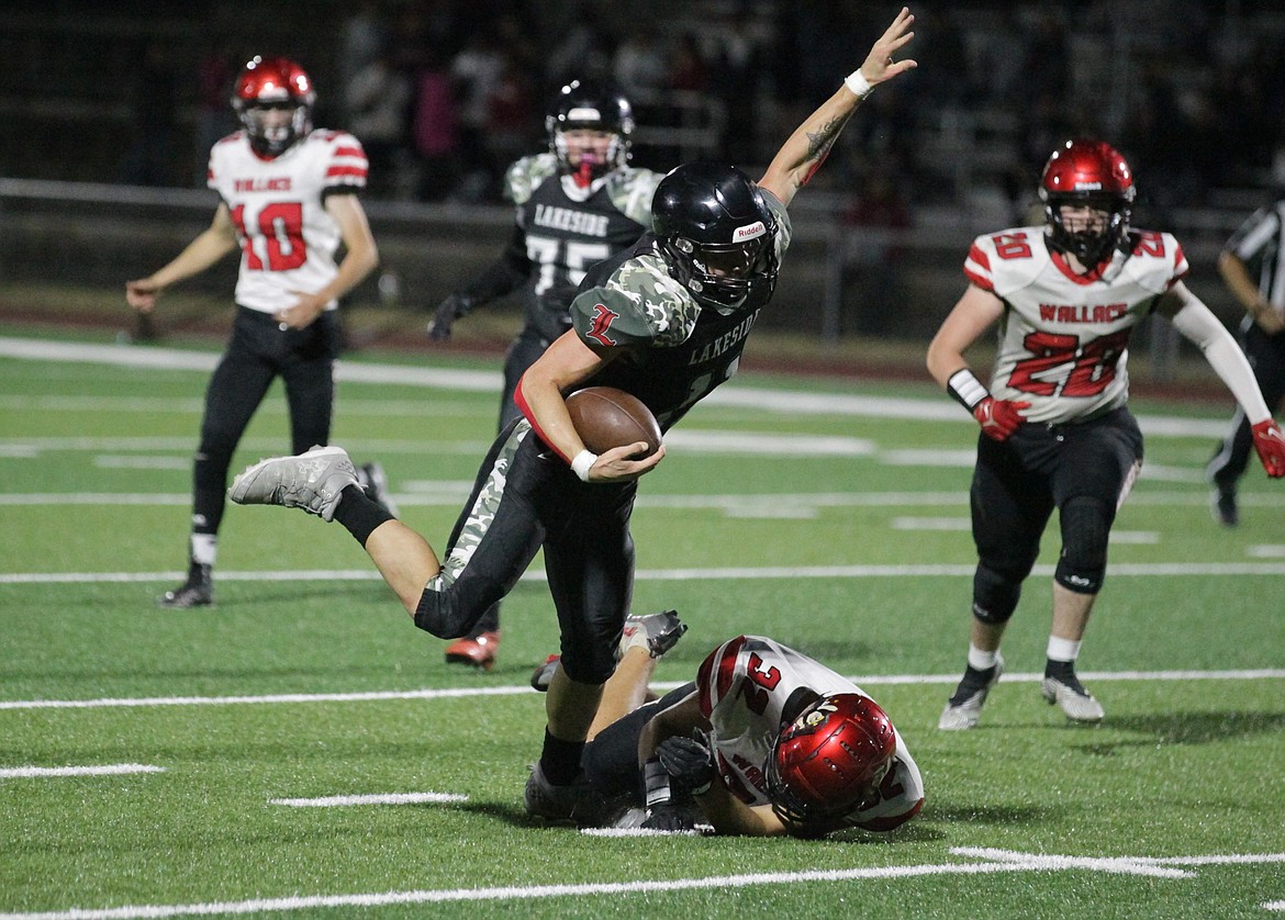 JASON ELLIOTT/Press
Lakeside senior fullback Jarius SiJohn-Moffitt breaks the tackle of Wallace defensive end Reece Williams during the first quarter of Friday's game at the Marimn Health Coeur Center in Worley.