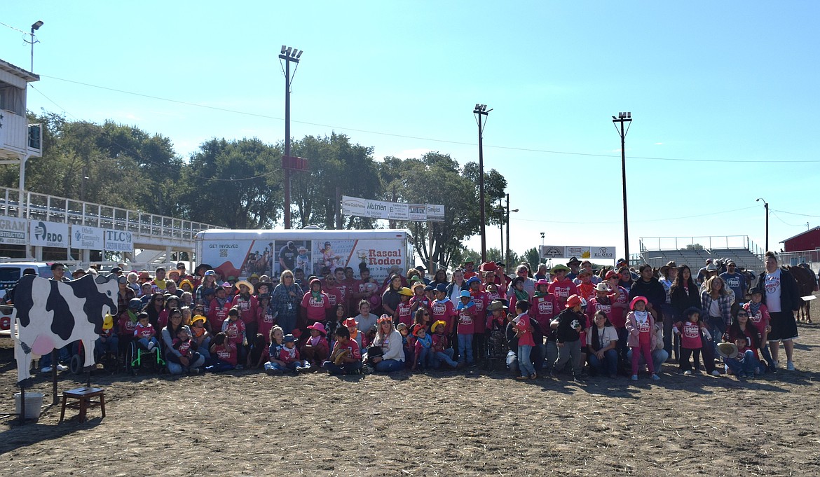 A group photo of all the participants, volunteers and coordinators of the Rascal Rodeo, an all-ages adaptive rodeo for people with disabilities.