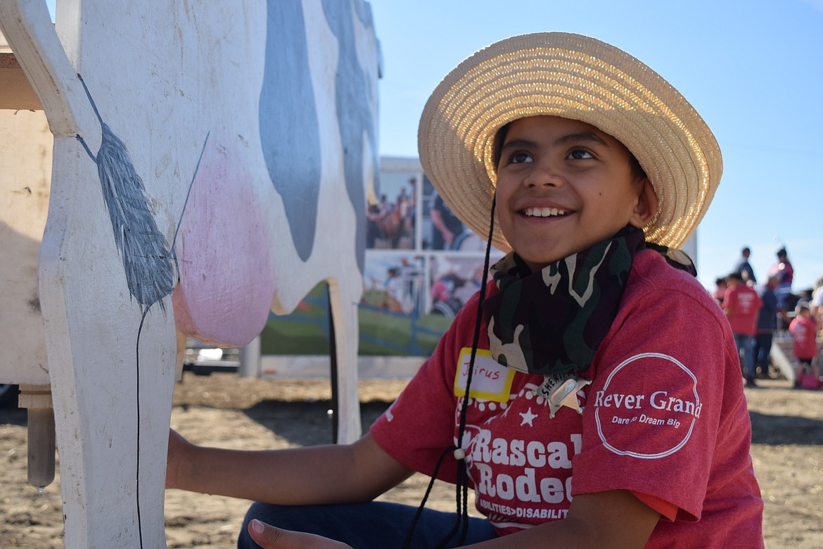 Jairus milks a cow at the Rascal Rodeo, an all-ages adaptive rodeo for people with disabilities.