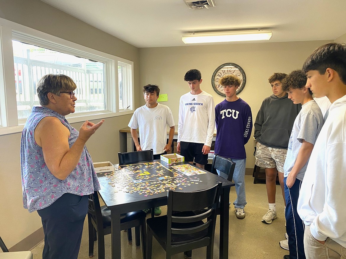 Roberta Ewert, director of the Canvas Food Pantry, gives a tour of the pantry facilities to several members of Coeur d'Alene High School's varsity boys soccer team Friday.