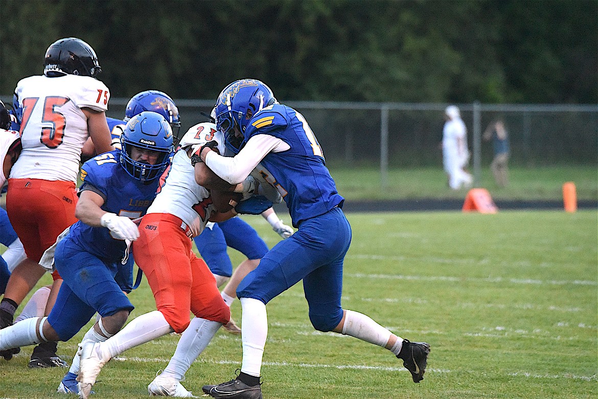 Libby's Drake Wofford helps make a tackle Friday, Sept. 13, 2024, against Ronan at Loggers Stadium. (Scott Shindledecker/The Western News)