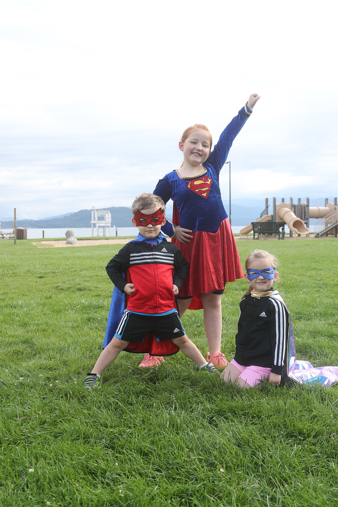 Isaiah, Adeline and Emory Beck give their best superhero post before the start of the Find Your Strength Family Fun Run.