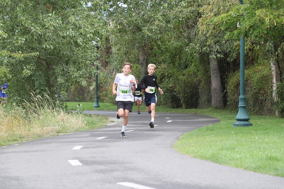 Theo Vanderbeek, left, and Kai Sinatra, right, race along Sand Creek in the 5K run during Saturday's Find Your Strength Family Fun Run. Sinatra would go on to edge Vanderbeek by two seconds in the 10-14 male division.