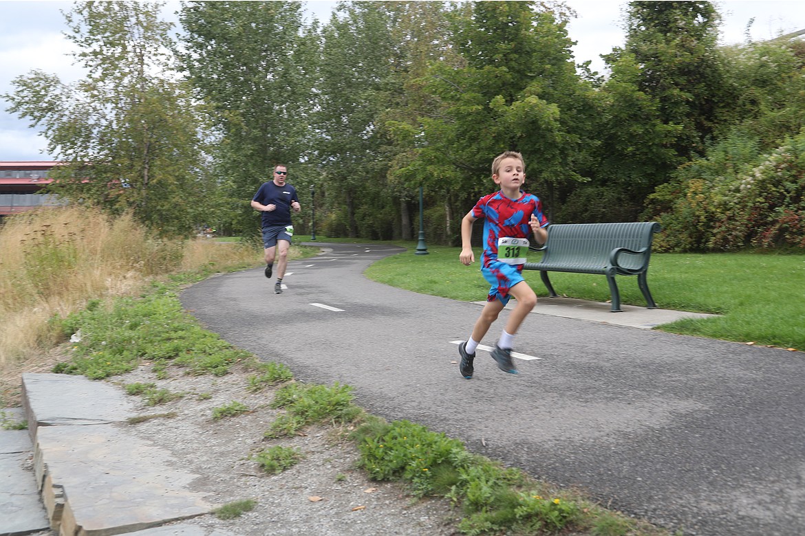 Eli Boekenoogen charges ahead of his dad, Scott Boekenoogen, during Saturday's Find Your Strength Family Fun Run.