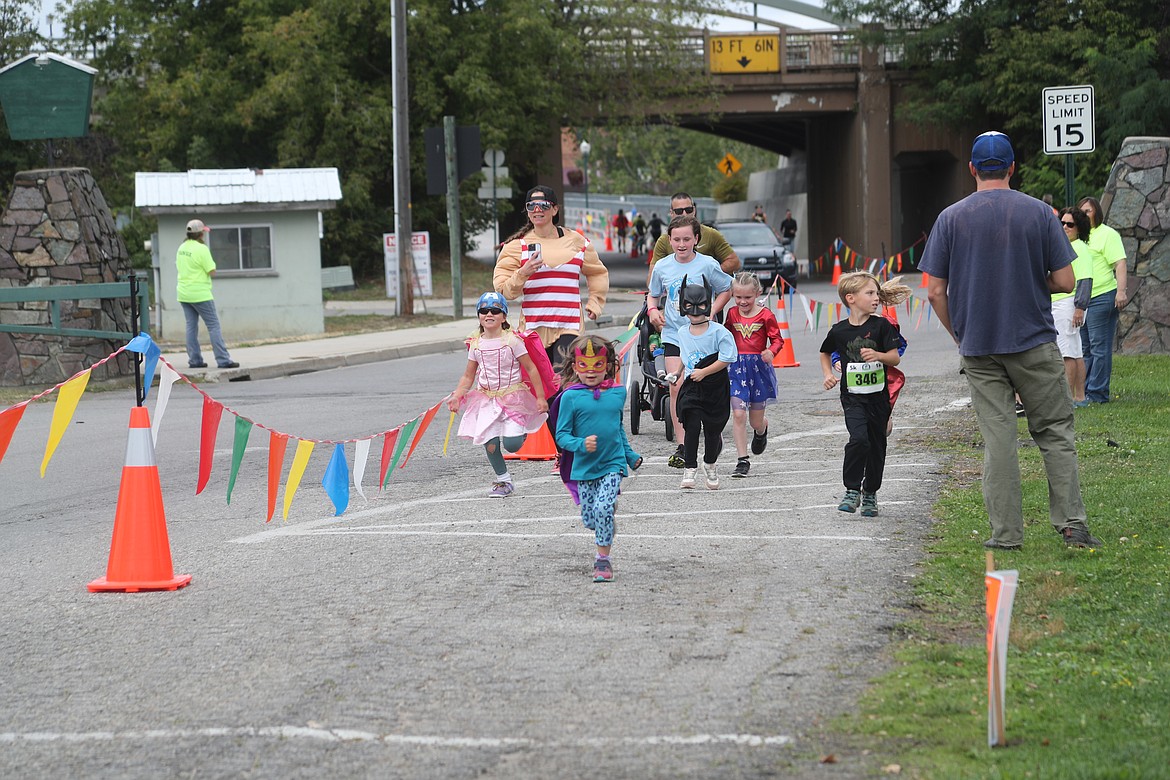 A group of runners race along Bridge Street as they approach the finish line during Saturrday's Find Your Strength Family Fun Run's 1K race.