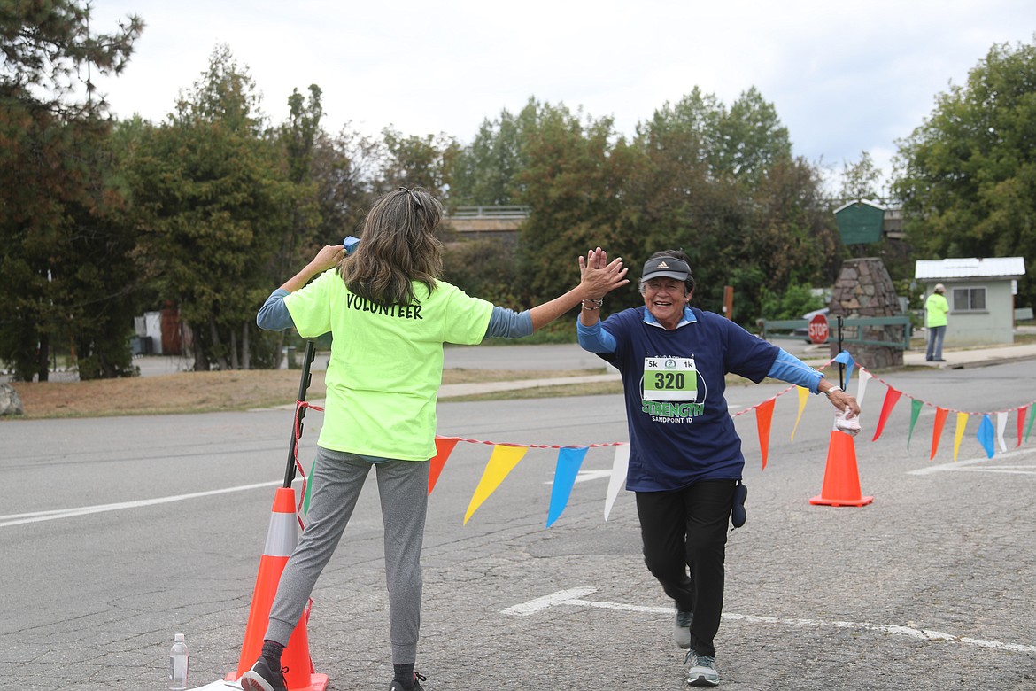 Amelia Boyd gives Isabel Hollriegel a high five as she enter the home stretch of the Find Your Strength's Family Fun Run's 5K race.