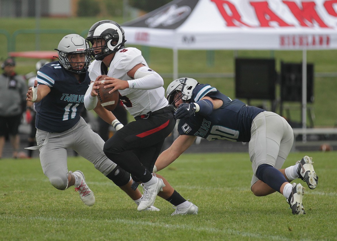 MARK NELKE/Press
Jericho Shawver (11) and Garrett Leonard (30) of Lake City pursue Highland quarterback Keaton Belnap (9) during the first half Saturday at Van Troxel Field.