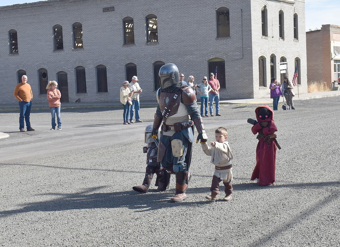 Marcus Dingman leads his 3-year-old twins Mandalorian Olly, left, and Jedi Knight Kai and 5-year-old daughter Willa, a Jawa for the day, down Willard Street in the Hartline Community Days parade Saturday morning. Dingman’s 8-year-old son Elliot rode his bike separately dressed as Spiderman. Having fun as a family - “This is the way.”