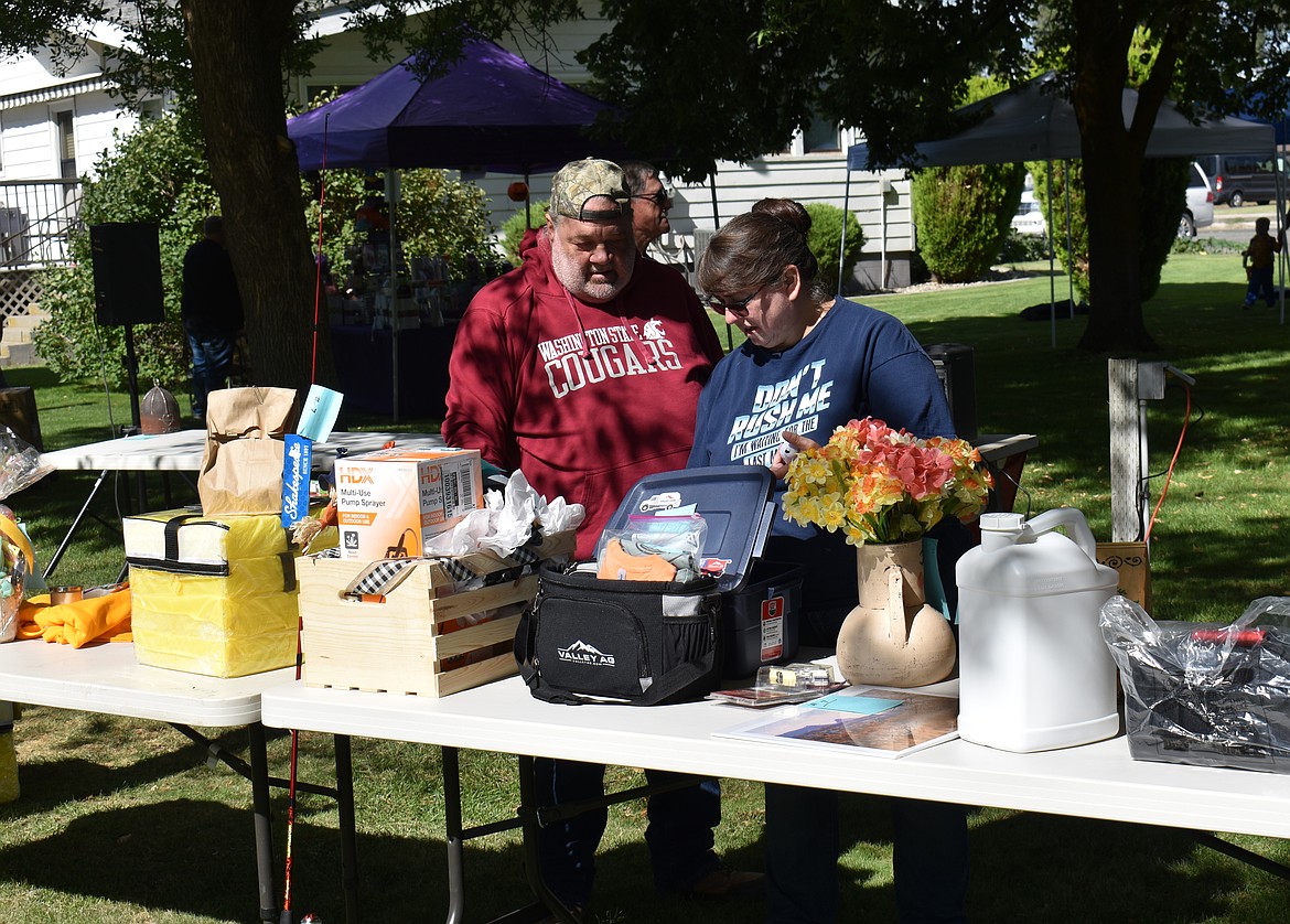 David, left, and Tammy Rinehart of Chelan look over auction items at Hartline Community Days Saturday. The auction itself raised about $4,000, according to organizer Lynn Franklin, not counting the other fundraisers going on at the park.