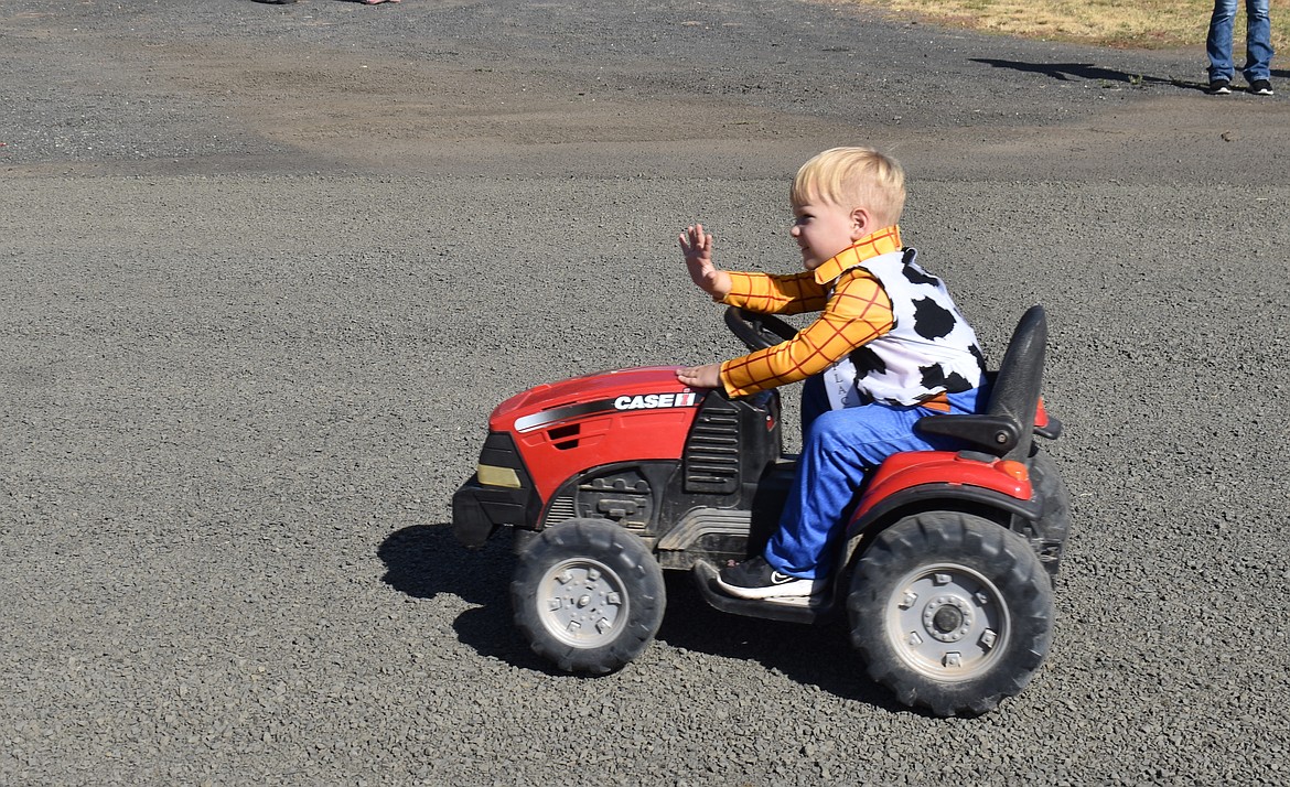 Cason Thomas, 4, waves to the crowd from his tractor in the Hartline Community Days parade Saturday morning.