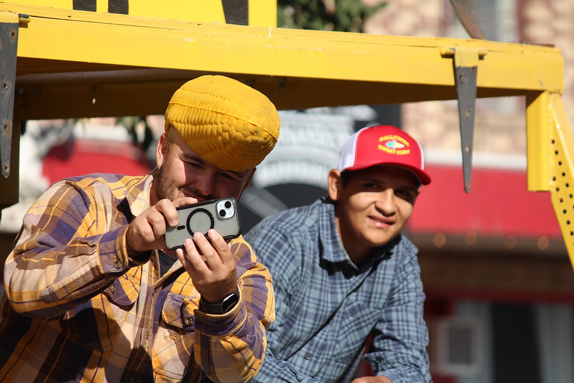 A cornhead from Kallstrom Sweet Corn, the 2024 Farm Family of the Year, snaps a photo as he travels the Farmer-Consumer Awareness day parade route.