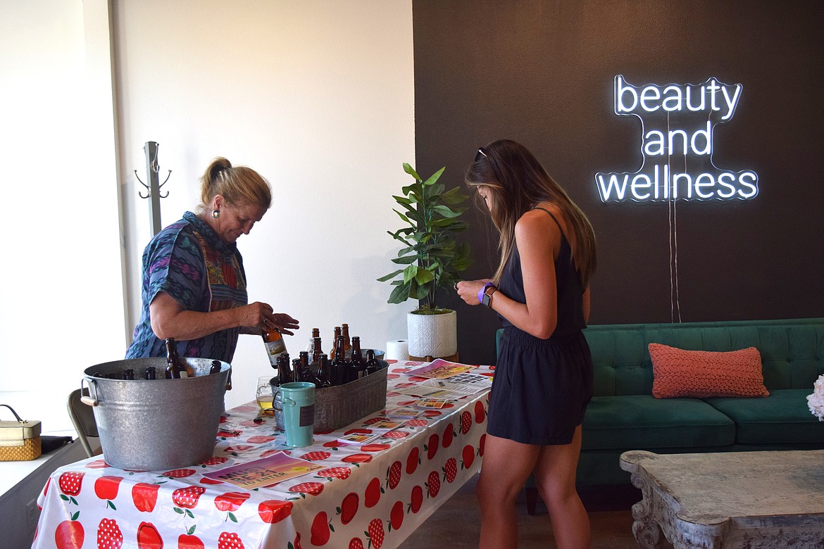 A Sip and Stroll participant gets a tasting sample and C. Michelle's Salon & Spa.