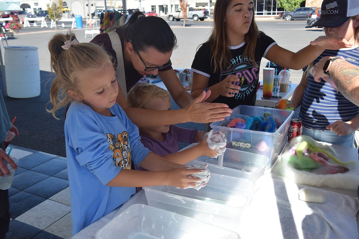 Two children, Alexa, left and Joanna, right learn how to make felt soap at the Art on Third event.