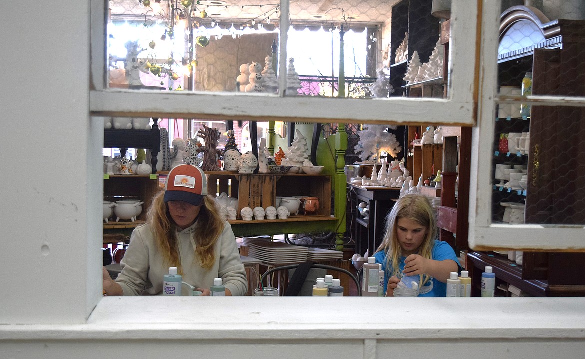 Chaeli Ayers and Allie Ayers paint pottery together on Saturday at the Artgarden.