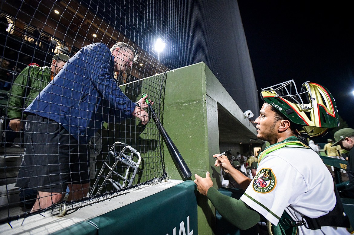 Glacier catcher Freddy Guilamo (19) signs a bat for a fan after the Range Riders 2-0 win over Yolo  during Game 1 of the Pioneer League Championship Series at Glacier Bank Park on Tuesday, Sept. 17. (Casey Kreider/Daily Inter Lake)