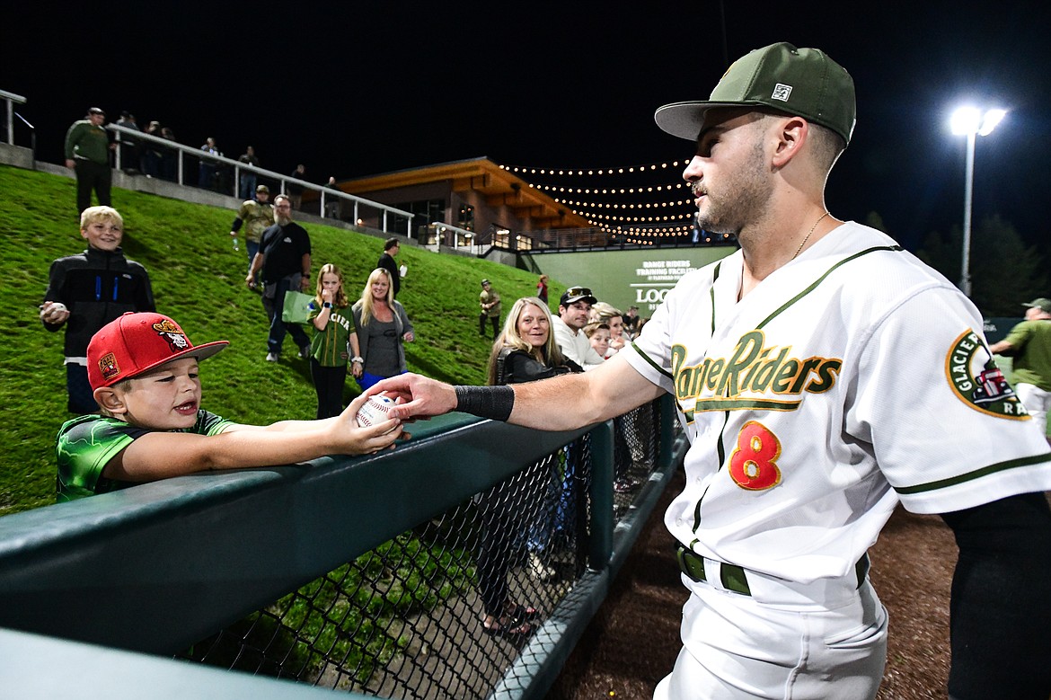 Glacier first baseman Ben Fitzgerald (8) hands a baseball to a young fan after the Range Riders 2-0 win over Yolo  during Game 1 of the Pioneer League Championship Series at Glacier Bank Park on Tuesday, Sept. 17. (Casey Kreider/Daily Inter Lake)