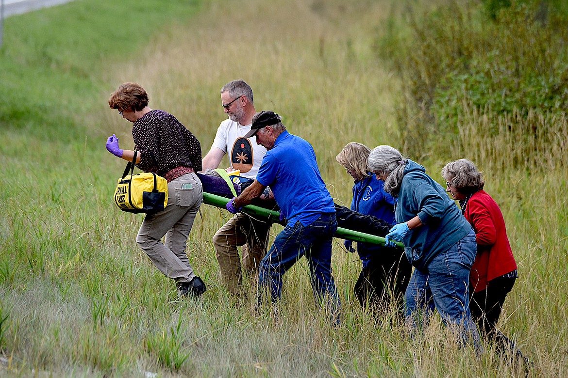 Members of Libby Volunteer Ambulance take a man from the scene of an traffic accident Tuesday evening on U.S. 2, south of Libby. (Scott Shindledecker/The Western News)