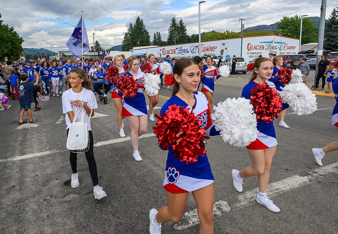 The cheerleaders walk in the parade.