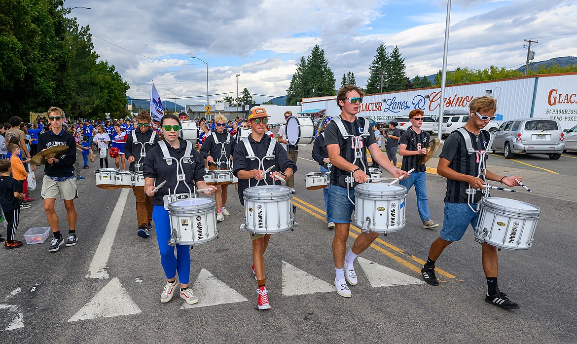 The drumline plays in the parade.